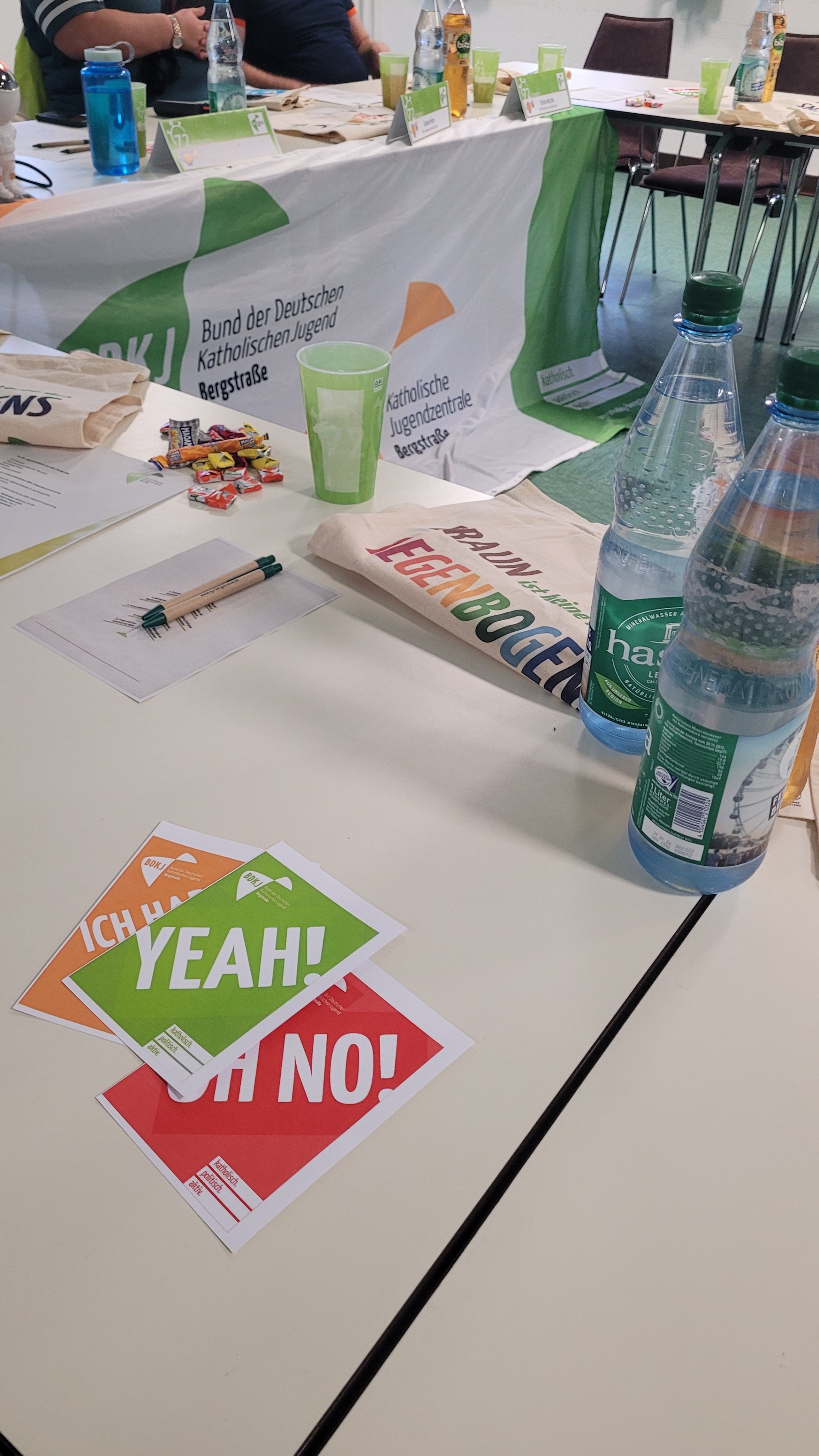 Auf einem tisch liegen grüne, gelbe, rote Karten mit Wasserflaschen.