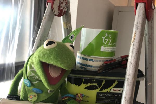 Kermit der Forsch -sitzt auf einer Leiter