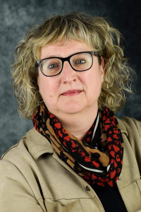 Eine Frau mit Brille und einem Schaal lächelt