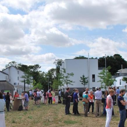 Die Teilnehmer/innen des Studientages im Gespräch mit den jungen Erwachsenen auf der Wiese vor dem Jugendhaus Don Bosco in Mainz.
