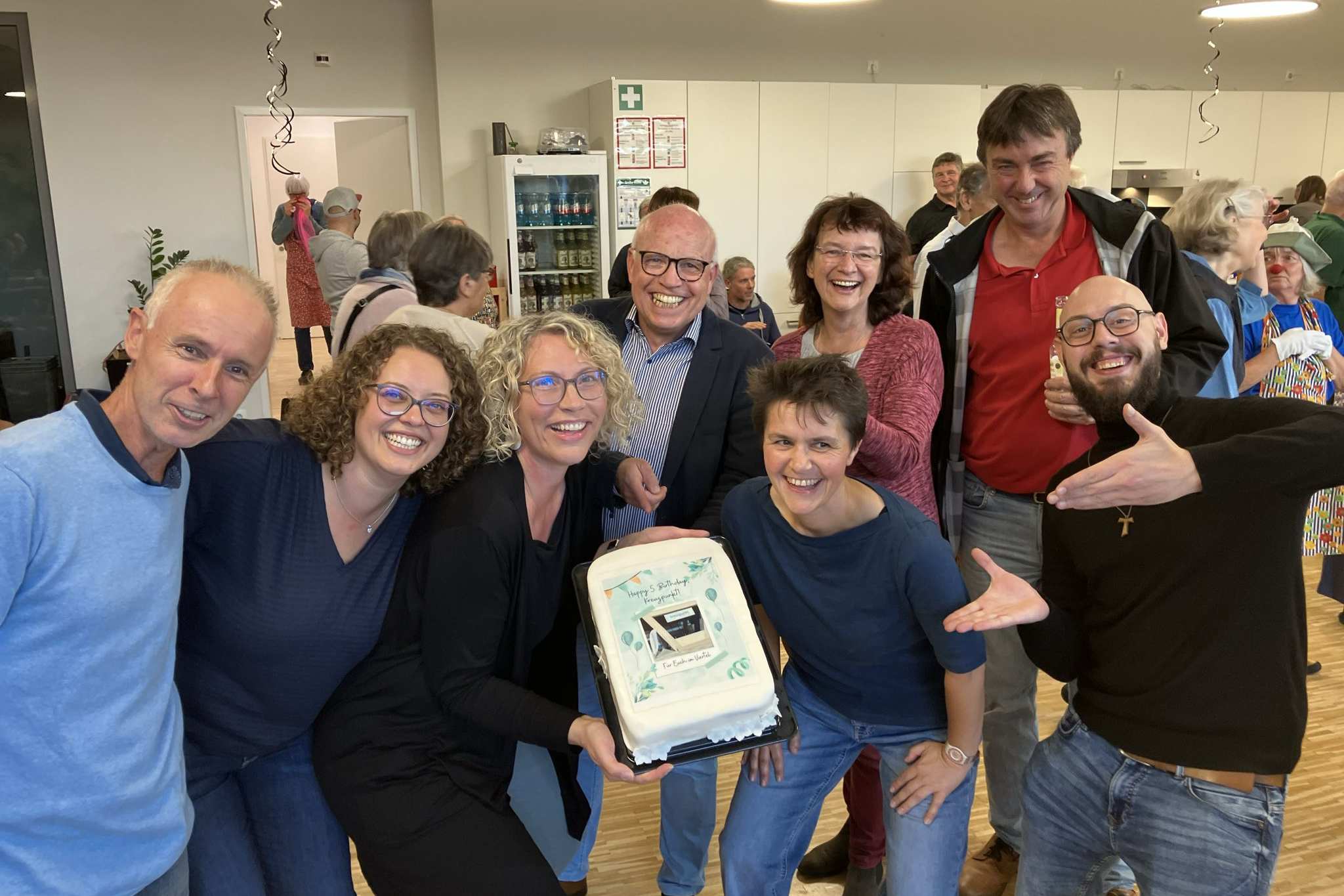 Kreuzpunktmitarbeiterinnen präsentieren eine selbst gebackene Torte