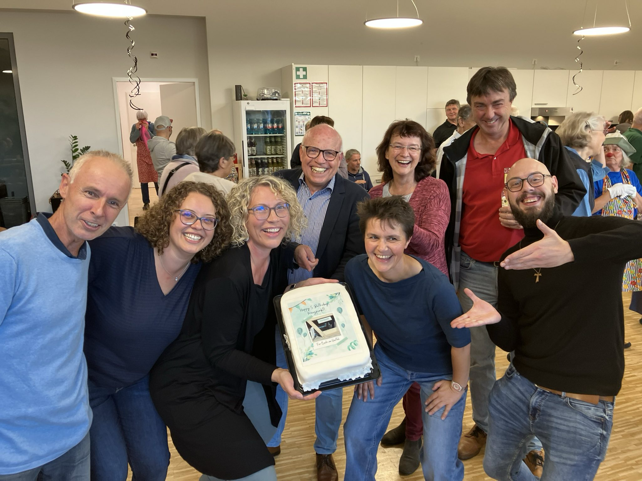 Kreuzpunktmitarbeiterinnen präsentieren eine selbst gebackene Torte