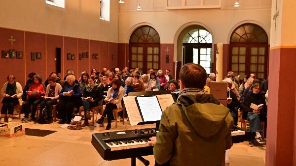 70 Teilnehmende am Wochenende Neue Geistliche Musik singen zusammen in einer Kirche, vorne Tobias Landsiedel am Keyboard