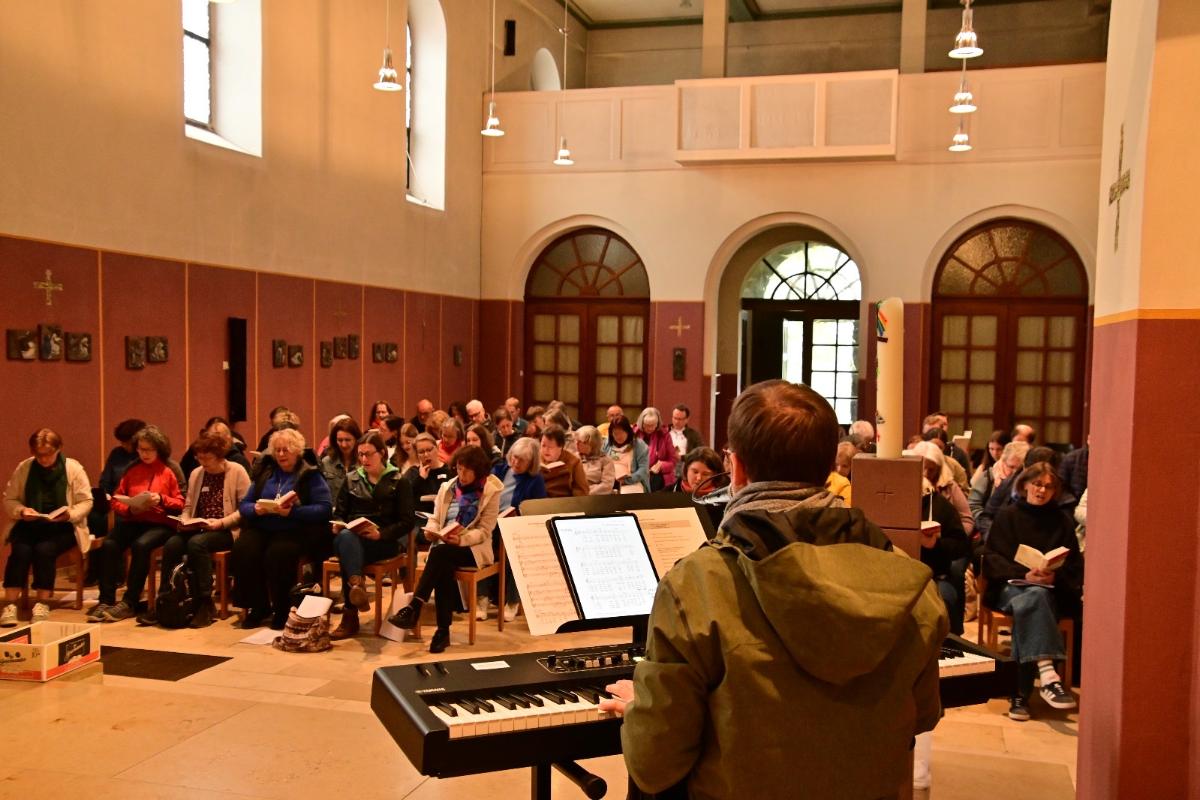 70 Teilnehmende am Wochenende Neue Geistliche Musik singen zusammen in einer Kirche, vorne Tobias Landsiedel am Keyboard