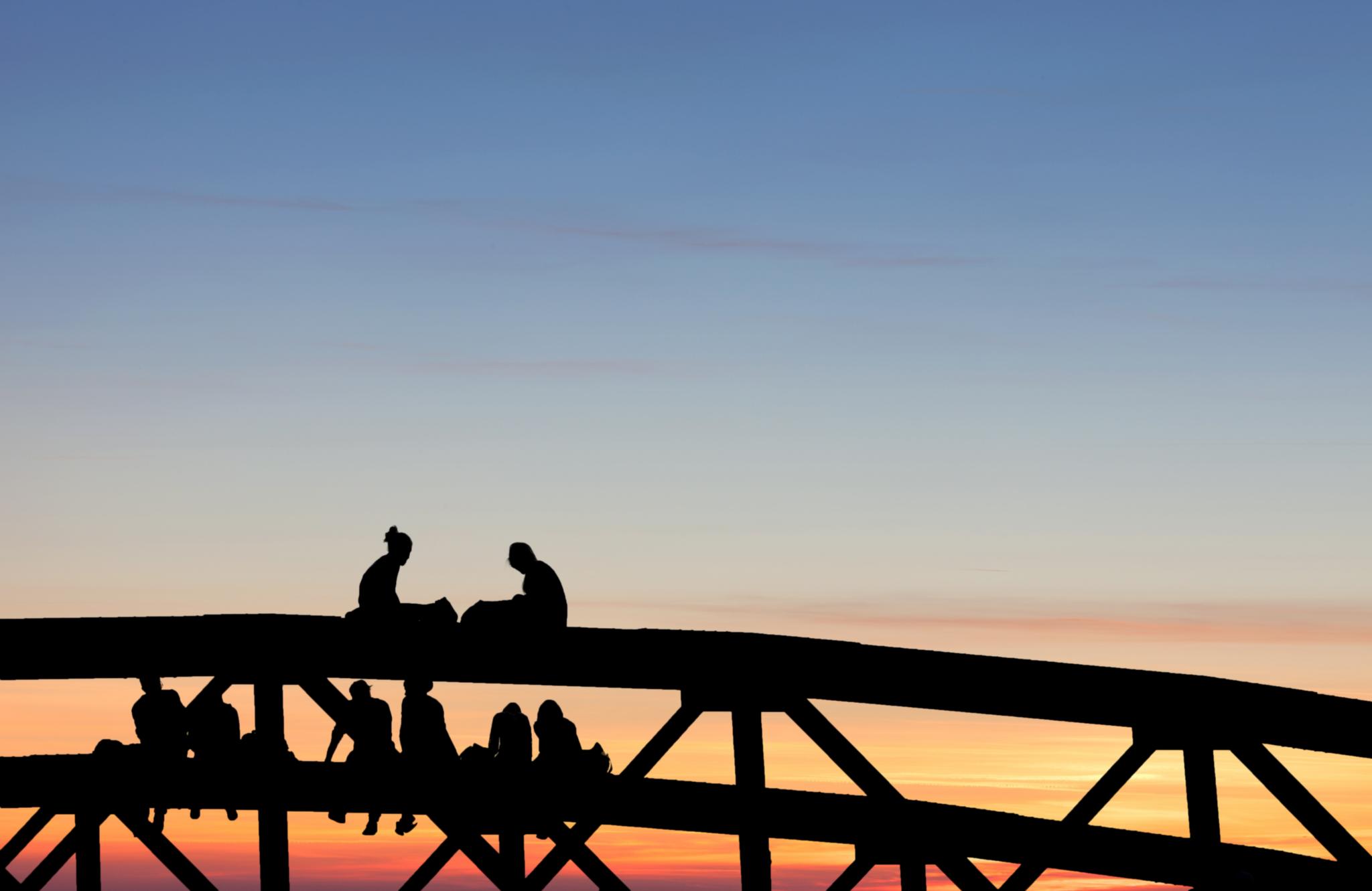 Silhouette von Menschen auf einer Brücke