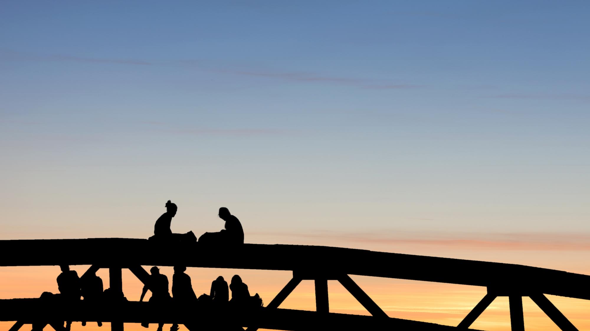 Silhouette von Menschen auf einer Brücke