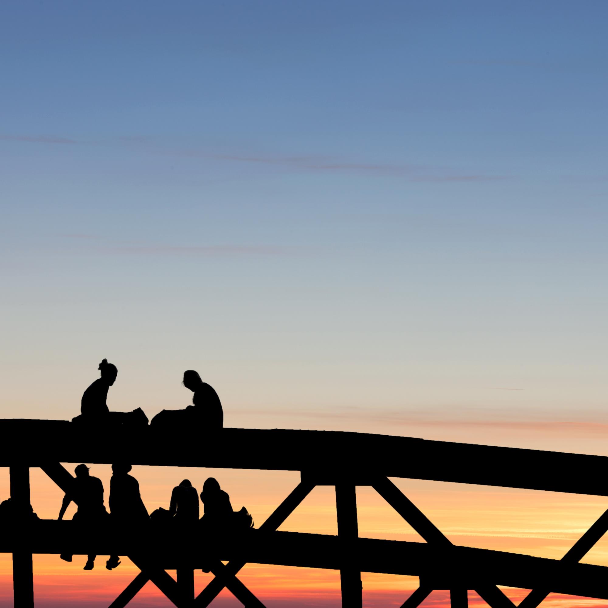 Silhouette von Menschen auf einer Brücke