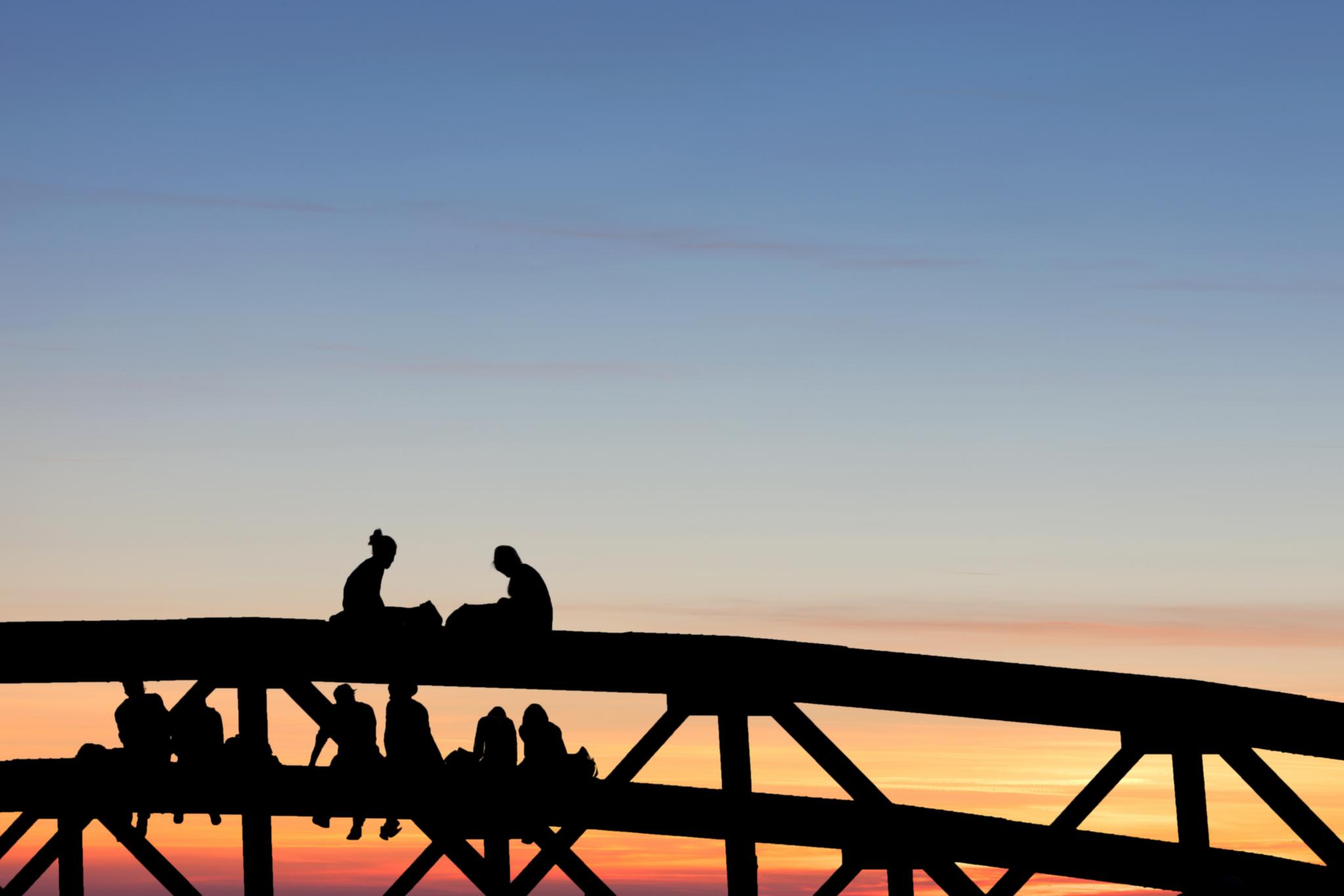 Silhouette von Menschen auf einer Brücke