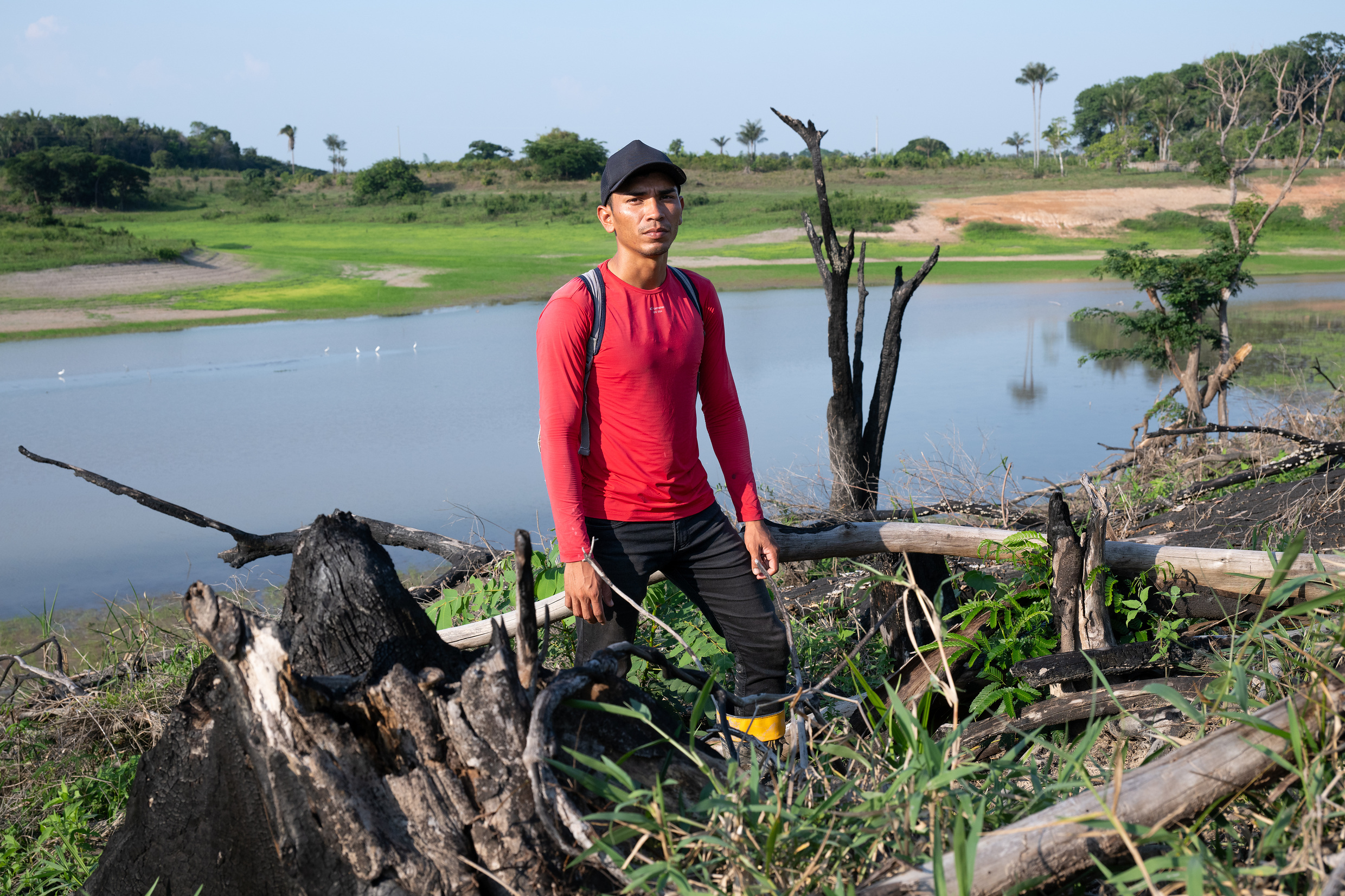 Gabriel da Silva (26) an einem abgebrannten Baum, Brandrodung in direkter Nachbarschaft der Mura-Gemeinde Lago de Soares