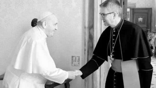 Papst FRanziskus und Bischof Kohlgraf reichen sich die Hände, das Bild ist in Schwarzweiß umgefärbt, da der Papst gestorben ist