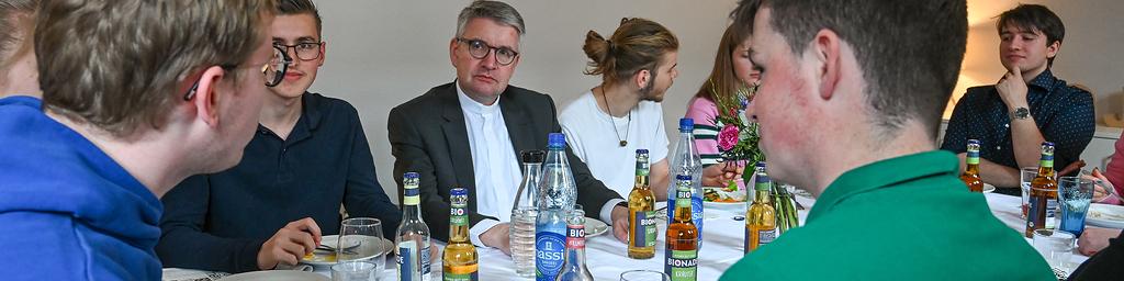 Peter Kohlgraf (m.), Bischof von Mainz, bei einem Mittagessen mit Freiwilligen des Christlichen Orientierungsjahres (COJ) am 19. April 2024 in Mainz