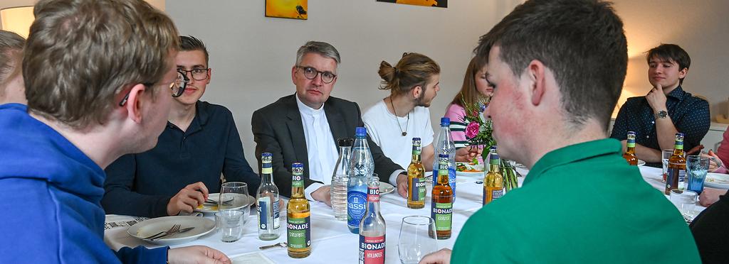 Peter Kohlgraf (m.), Bischof von Mainz, bei einem Mittagessen mit Freiwilligen des Christlichen Orientierungsjahres (COJ) am 19. April 2024 in Mainz