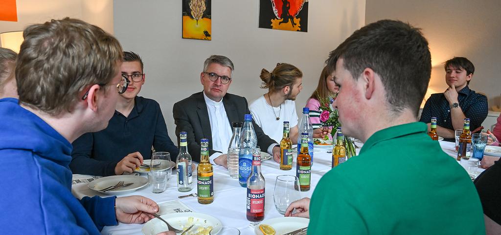 Peter Kohlgraf (m.), Bischof von Mainz, bei einem Mittagessen mit Freiwilligen des Christlichen Orientierungsjahres (COJ) am 19. April 2024 in Mainz