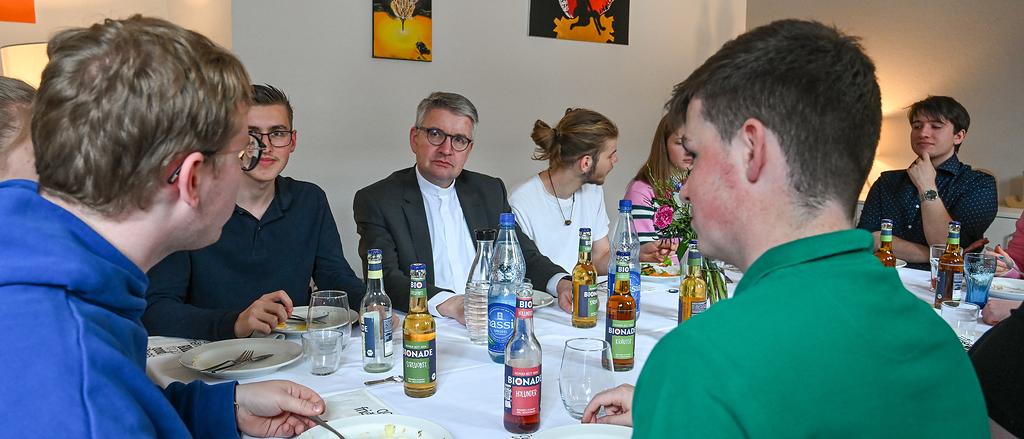 Peter Kohlgraf (m.), Bischof von Mainz, bei einem Mittagessen mit Freiwilligen des Christlichen Orientierungsjahres (COJ) am 19. April 2024 in Mainz