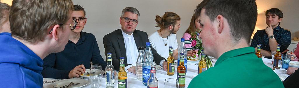 Peter Kohlgraf (m.), Bischof von Mainz, bei einem Mittagessen mit Freiwilligen des Christlichen Orientierungsjahres (COJ) am 19. April 2024 in Mainz