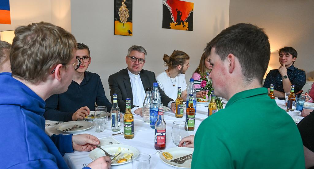 Peter Kohlgraf (m.), Bischof von Mainz, bei einem Mittagessen mit Freiwilligen des Christlichen Orientierungsjahres (COJ) am 19. April 2024 in Mainz
