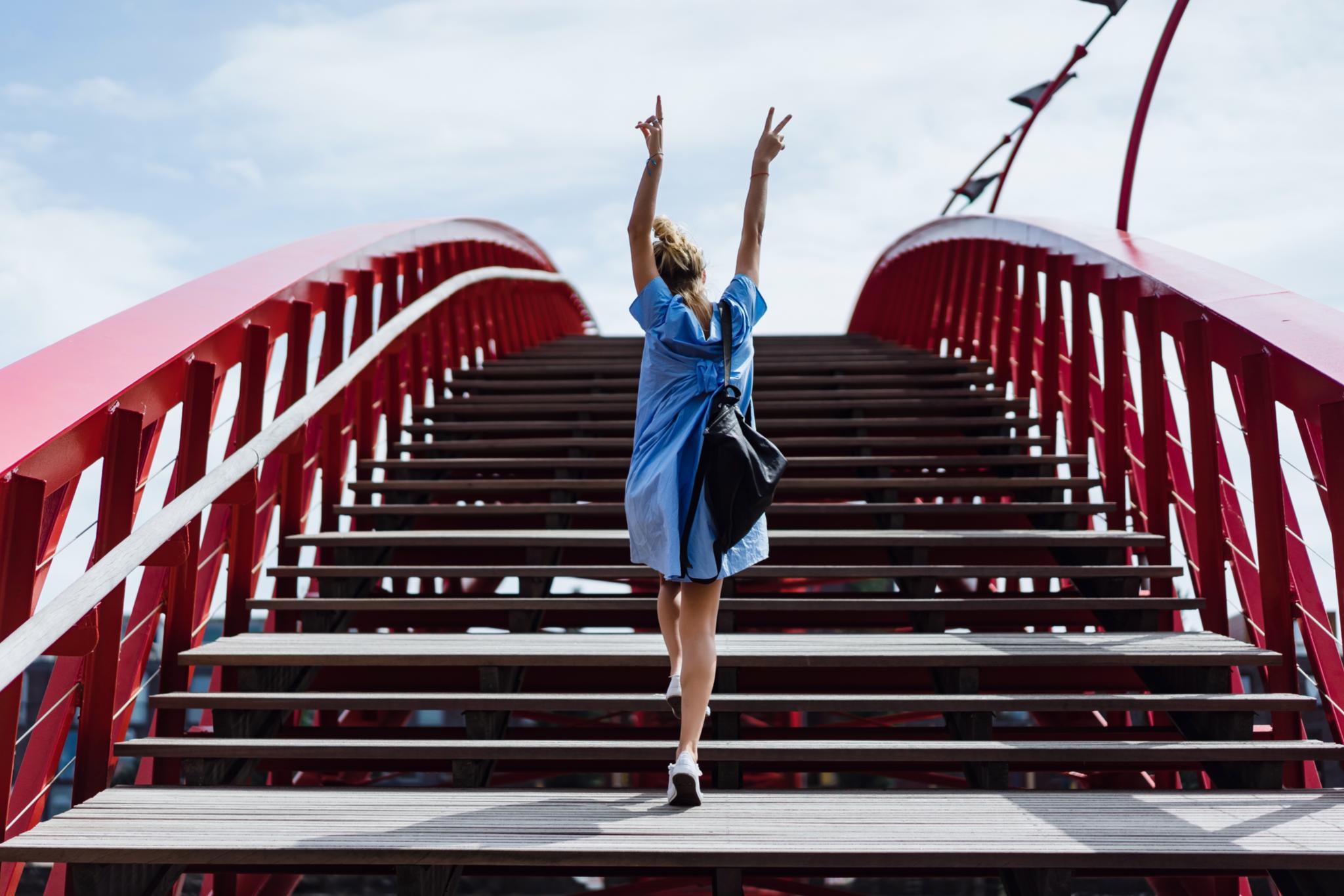 Frau in blauem Kleid auf Brücke