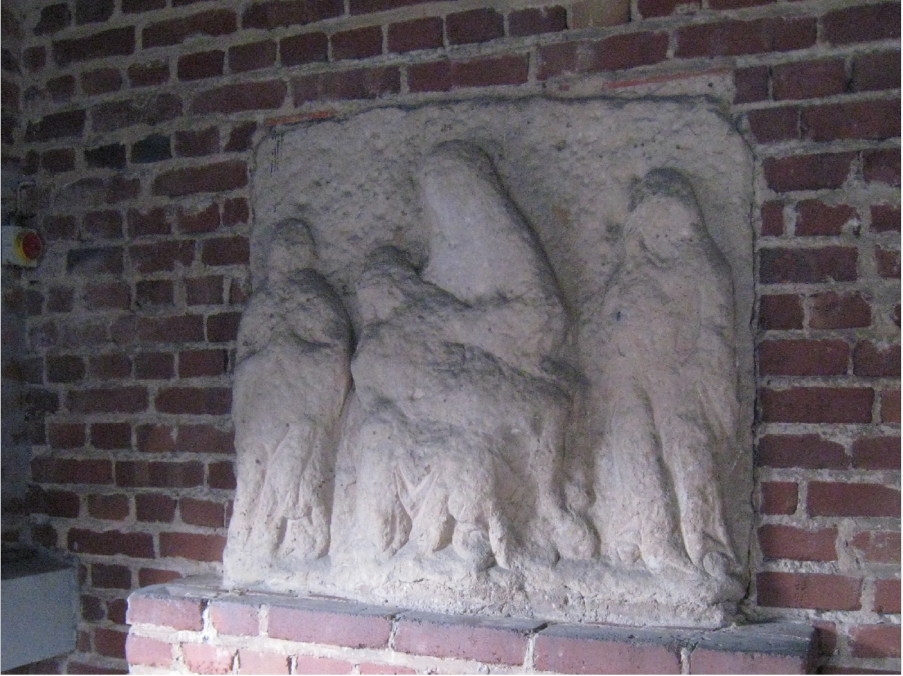 Steinrelief Pieta im Seiteneingang der Kirche Christkönig, Bischofsheim