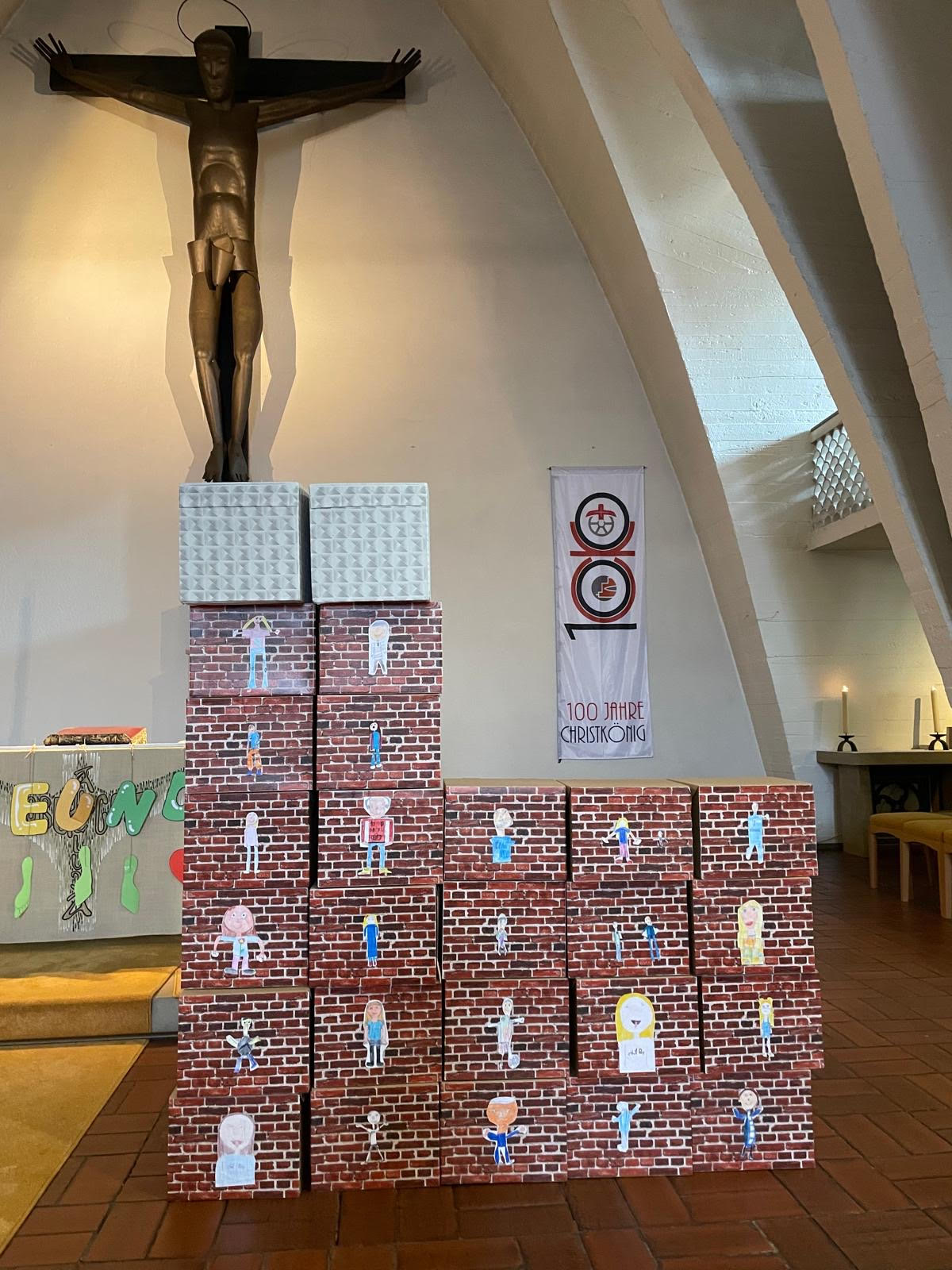 Ein stilisiertes Modell der Lirche Christkönig, Bischofsheim, gebaut aus backsteinartig bemalten Kartons, im Altarraum der Kirche Christkönig