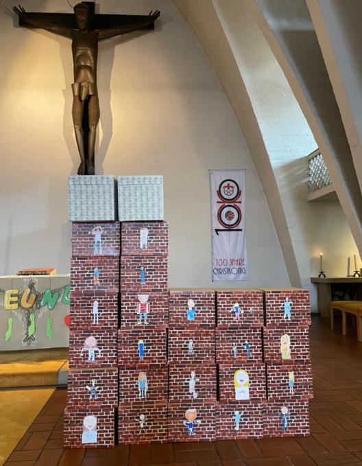 Ein stilisiertes Modell der Lirche Christkönig, Bischofsheim, gebaut aus backsteinartig bemalten Kartons, im Altarraum der Kirche Christkönig