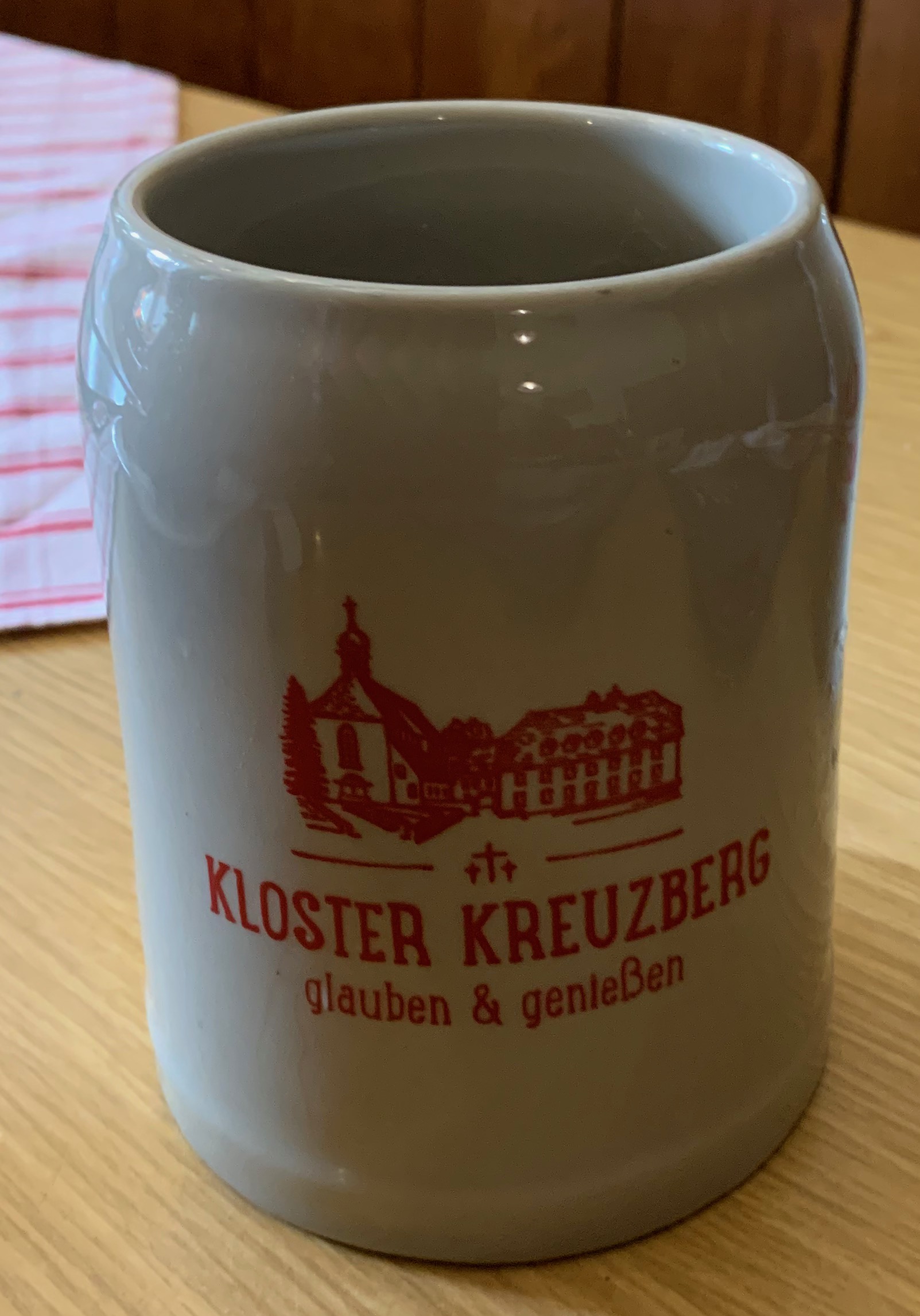 Ein Bierkrug mit der Beschriftung 'Glauben und Genießen - Kloster Kreuzberg'