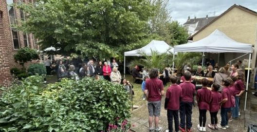 Der Kinderchor der Gemeinde Christkönig singt im Pfarrgarten vor zahlreichen Zuhörern
