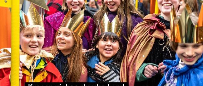 Kinder als Sternsinger in einer Straßenbahn mit Text 'Kronen ziehen durchs Land'