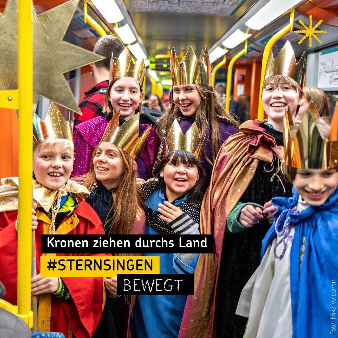Kinder als Sternsinger in einer Straßenbahn mit Text 'Kronen ziehen durchs Land'