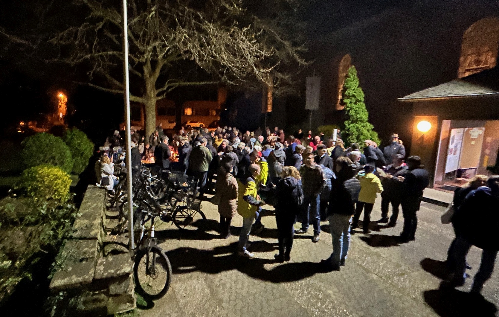 Gottesdienstbesucher verweilen auf dem Kirchplatz und unterhalten sich