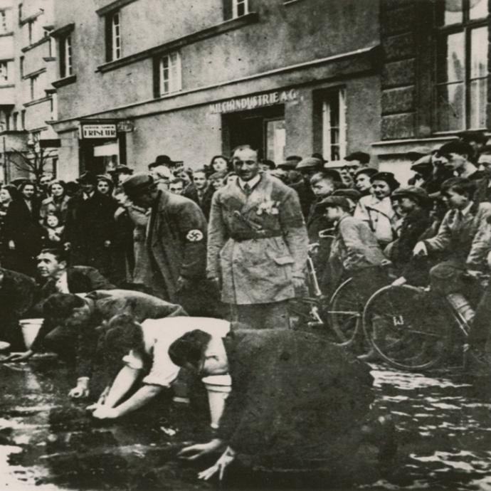 Nach der Annexion Österreichs sehen Anwohner zu, wie österreichische Nationalsozialisten Juden zwingen, den Bürgersteig zu schrubben. Wien, März 1938