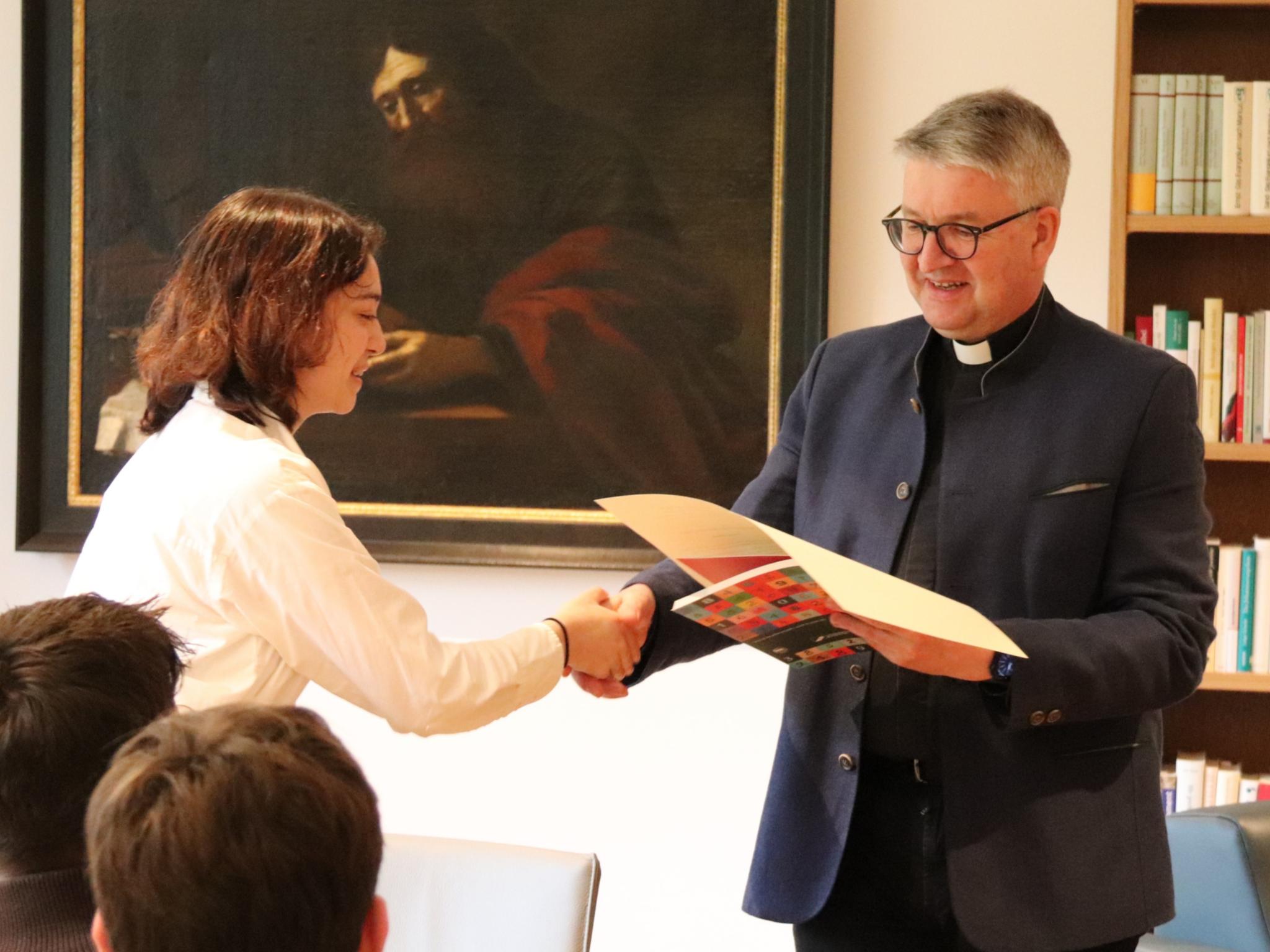 Cansu erhält die Urkunde von Bischof Peter Kohlgraf