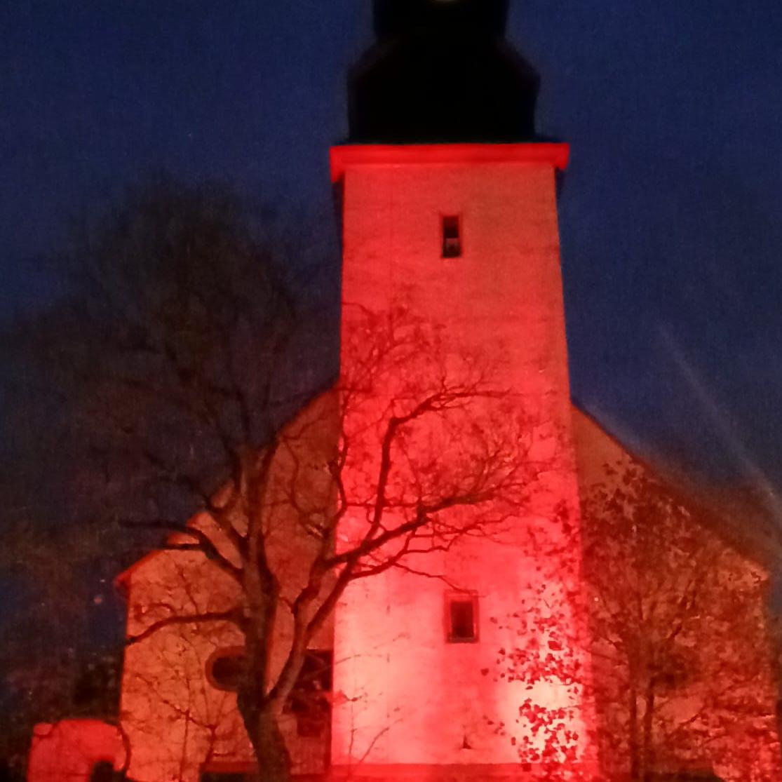 Glockenturm der St.-Remigius-Kirche Ober-Mörlen rot beleutet