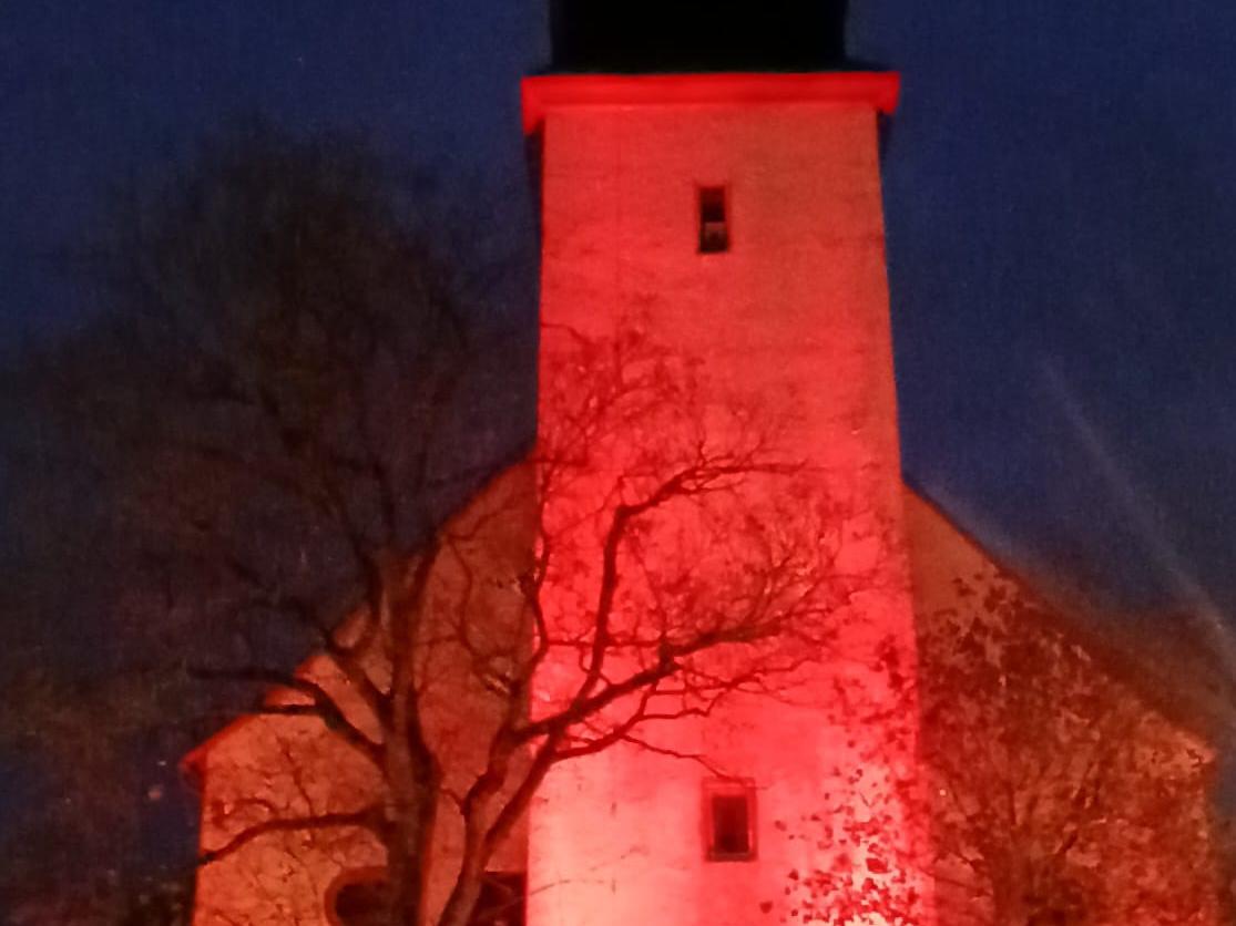 Glockenturm der St.-Remigius-Kirche Ober-Mörlen rot beleutet