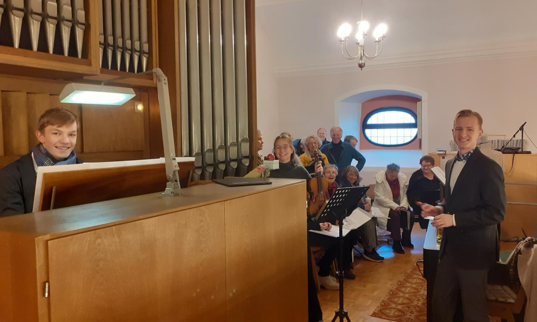 Die Akteure auf der Empore mit dem Chor im Hintergrund, links Noah Jüngel, Mitte Emma Ulowetz, rechts Witold Tuszynski