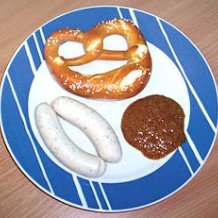 Weißwurst, Brezel, Senf auf einem blau-weißen Teller