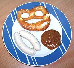 Weißwurst, Brezel, Senf auf einem blau-weißen Teller