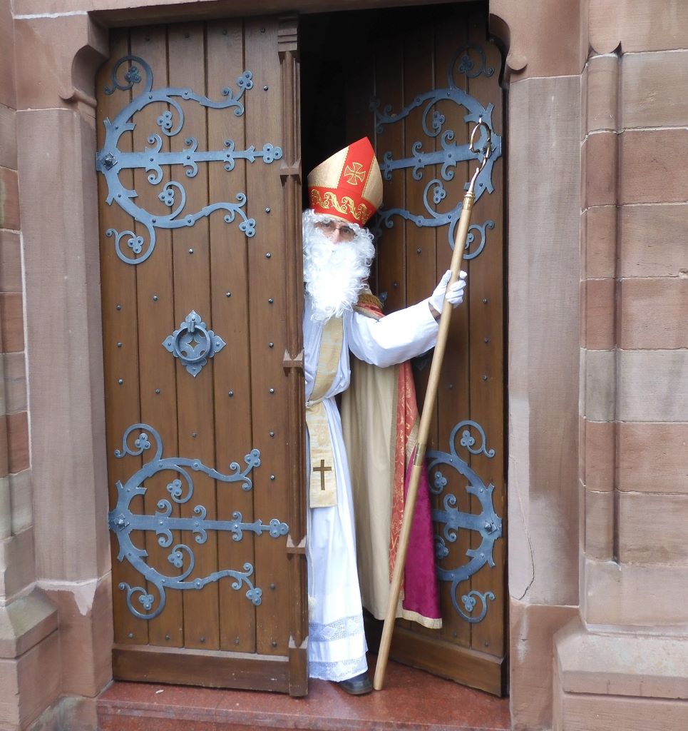 Als Bischof Nikolaus verkleideter Mann kommt aus einer Kirche.