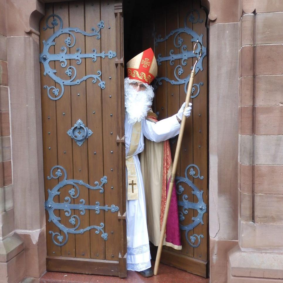 Als Bischof Nikolaus verkleideter Mann kommt aus einer Kirche.