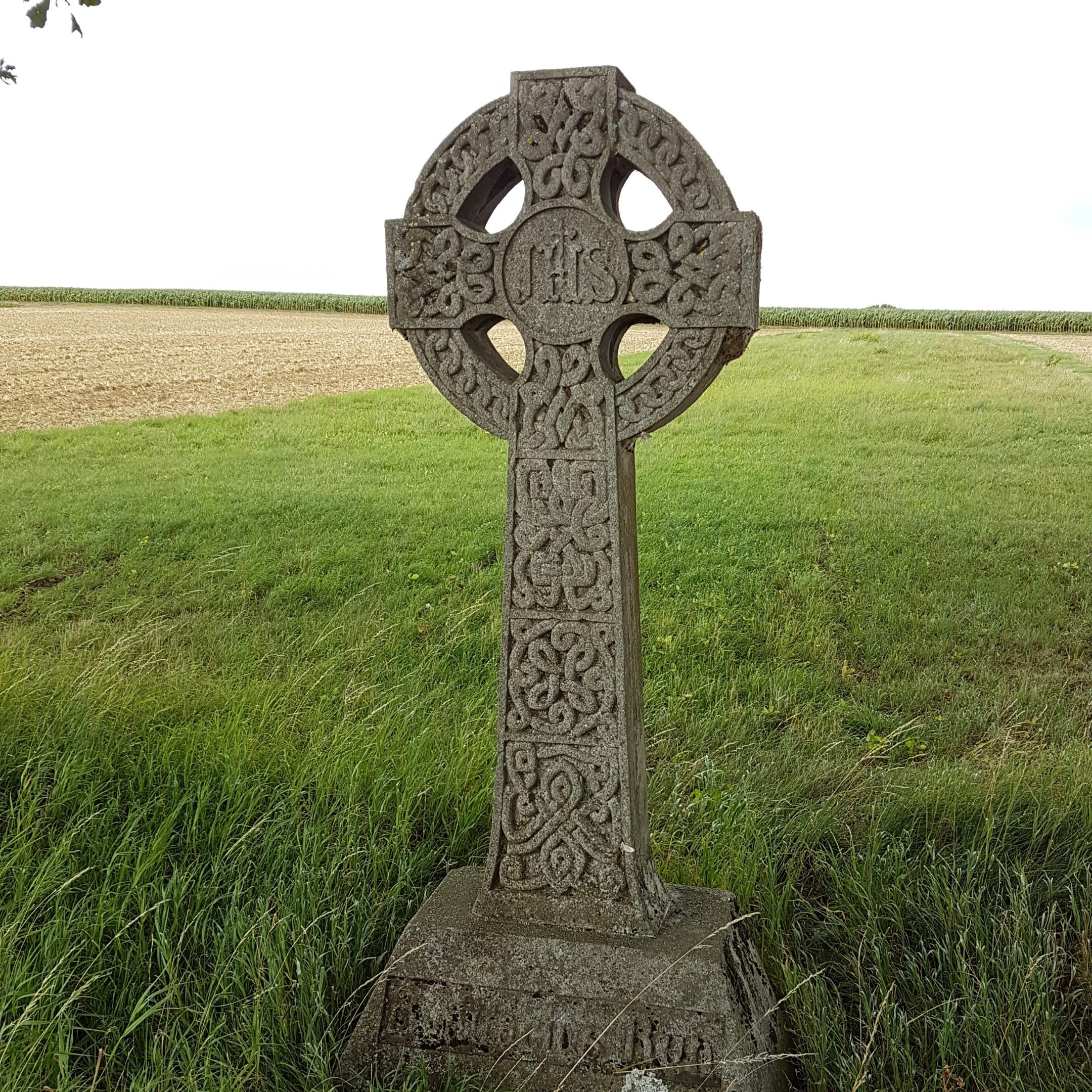 Irisches Kreuz im Vordergrund einer grünen Wiese