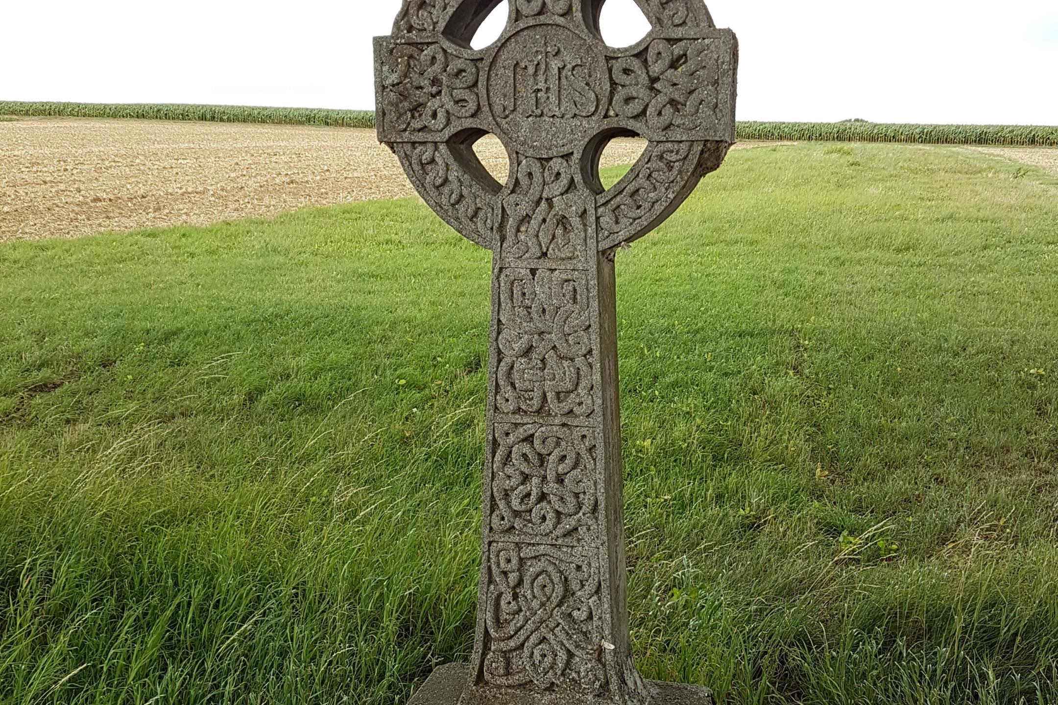 Irisches Kreuz im Vordergrund einer grünen Wiese