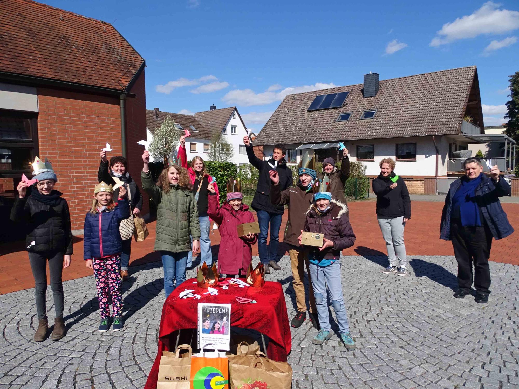 Büttelborn, 03. April 2022: Sternsingergruppe mit selbstgebastelten Friedenstauben auf dem Büttelborner Kirchplatz.