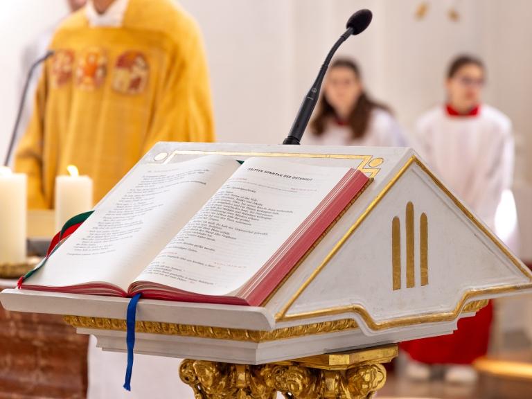 Bibel liegt aufgeschlagen auf Ambo in Kirche.