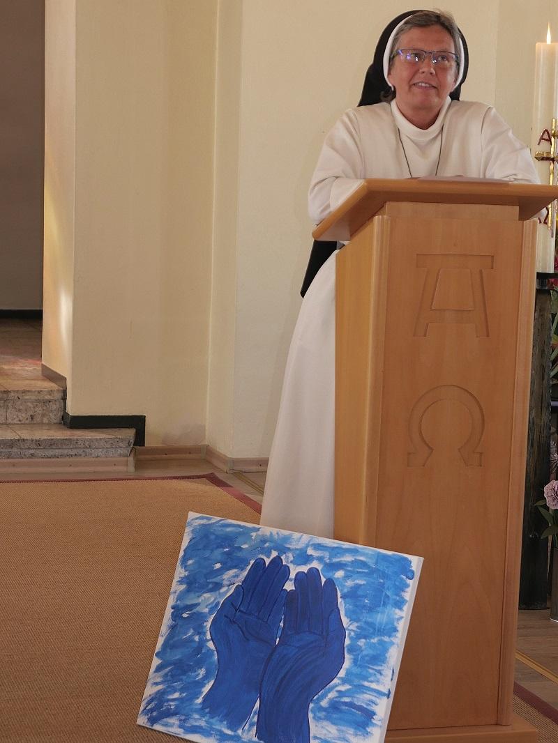 Ein Bild mit zwei blauen Händen stellte Schwester Judith Moormann in den Mittelpunkt ihrer Ansprache.