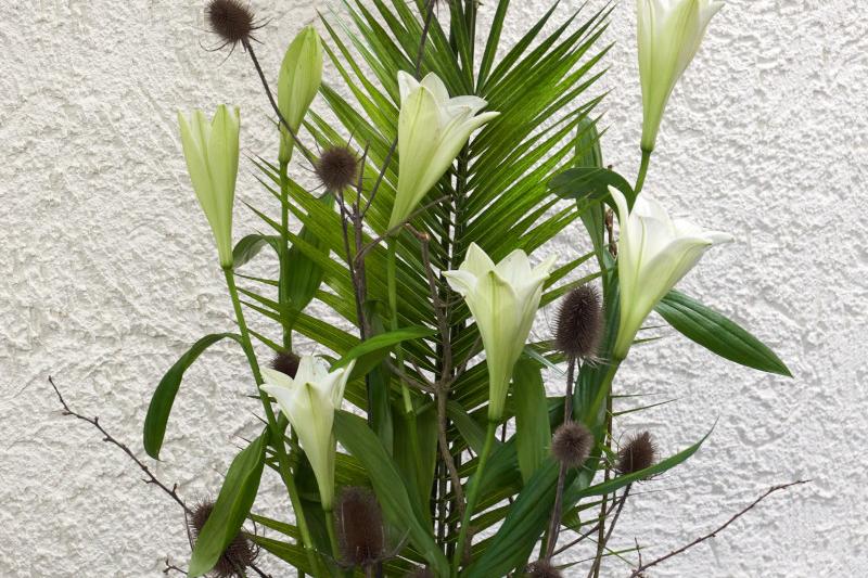 österliches Gesteck mit Kreuz, Lilien und Palmwedeln