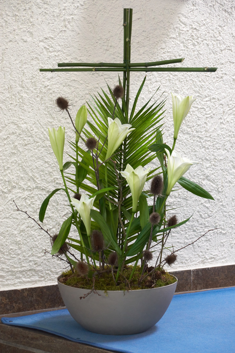 österliches Gesteck mit Kreuz, Lilien und Palmwedeln