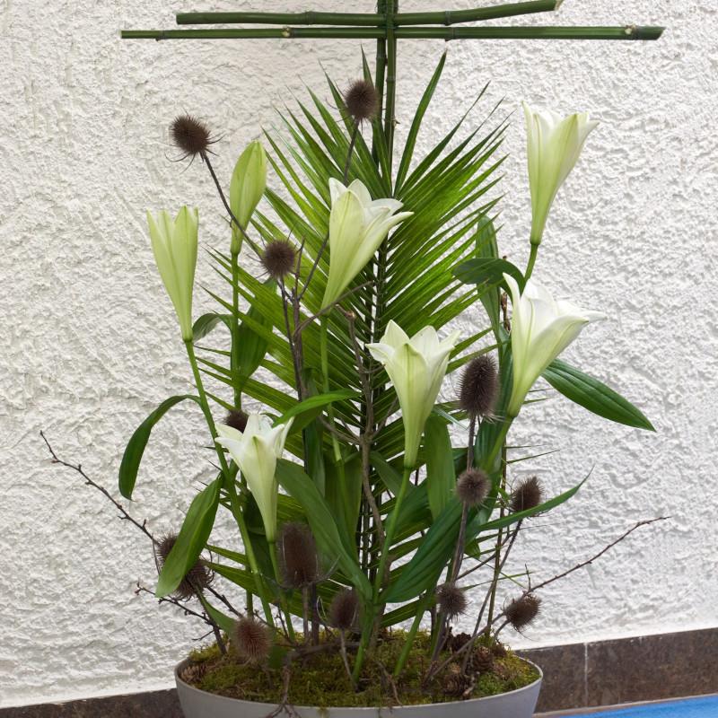 österliches Gesteck mit Kreuz, Lilien und Palmwedeln