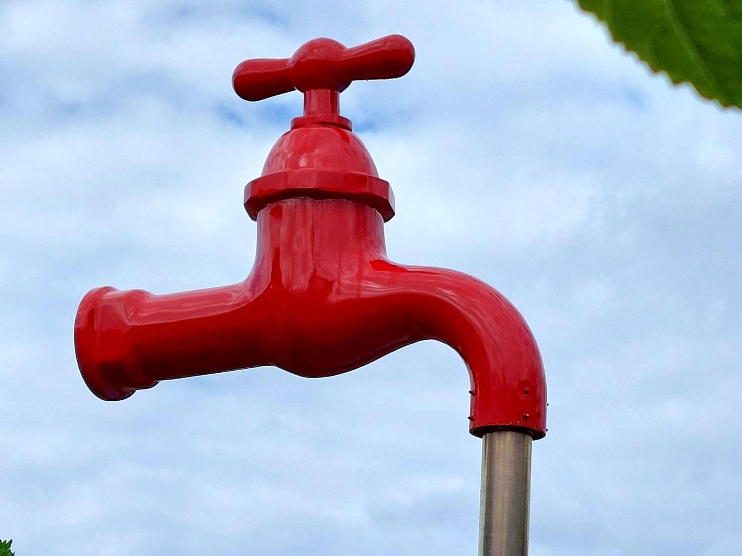 Wasserhahn steht auf Wasserstrahl