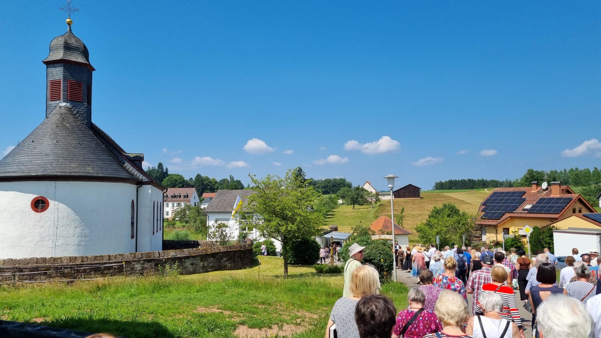 Ein langer Prozessionszug kehrt zur Barockkirche St. Luzia und St. Odilia zurück (c) Pastoralraum Odenwald/WW