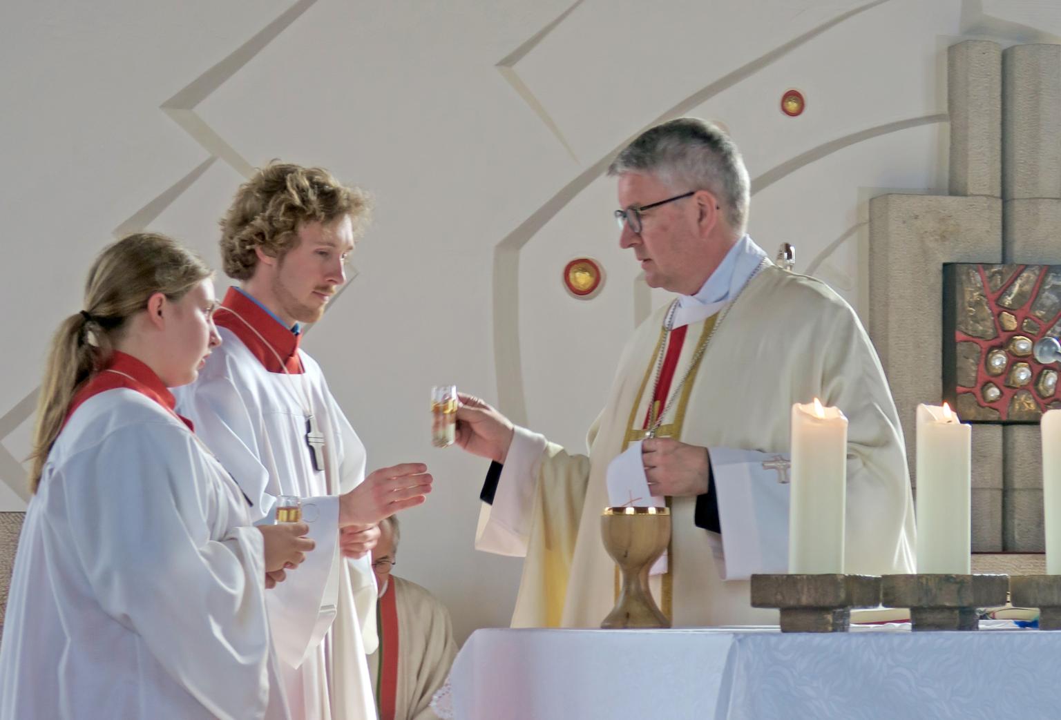 Während der Gabenbereitung bringen die Messdiener Anika Döbert und Sebastian Büchs Wasser und Wein zu Bischof Kohlgraf an den Altar (c) Christiane Raabe