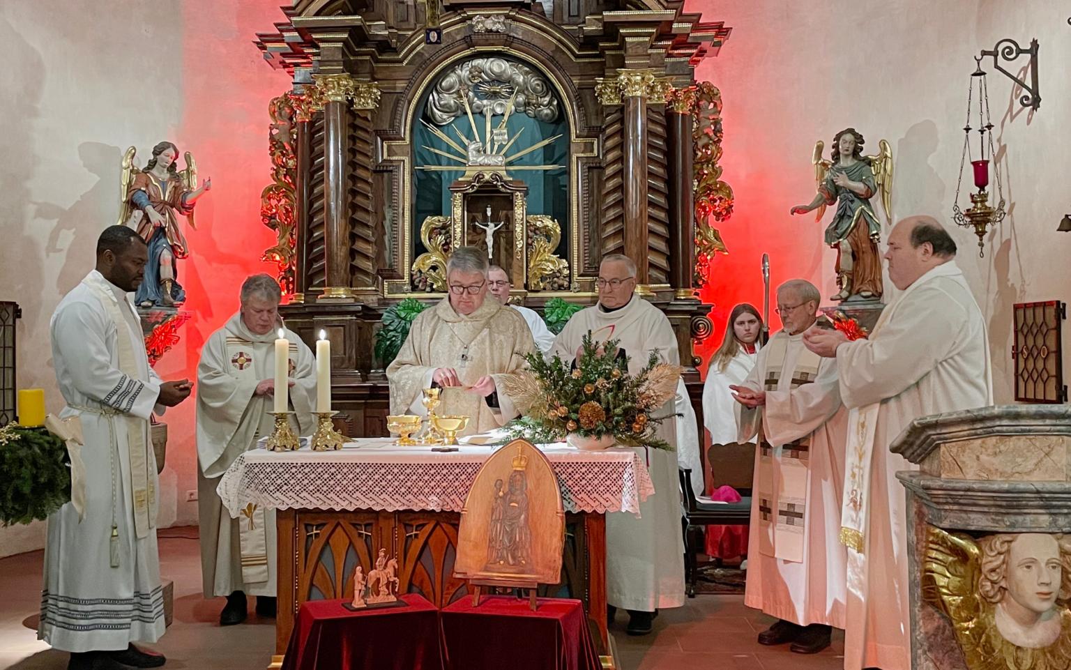 v.l.: Kaplan Cornelius Agbo, Leitender Pfarrer Harald Poggel, Bischof Peter Kohlgraf, Diakon Volkmar Raabe, Pfarrer i.R. Januarius Mäurer, Pfarrer Jozef Koscielny – Vordergrund Bildnis der Schwarzen Madonna des Odenwaldes und der kleinen Statue des heiligen Martin (c) Volkmar Raabe